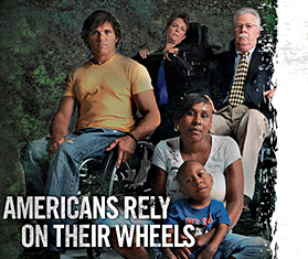 A group of wheelchair users seated against a dark background
